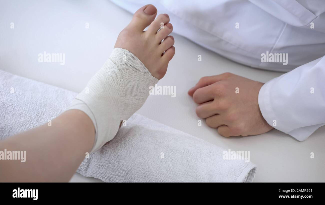 Un spécialiste de la rééducation qui bandait la cheville après une séance d'entraînement Banque D'Images