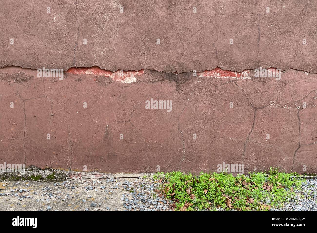 Un vieux mur fissuré en stuc peint dans une ruelle Banque D'Images