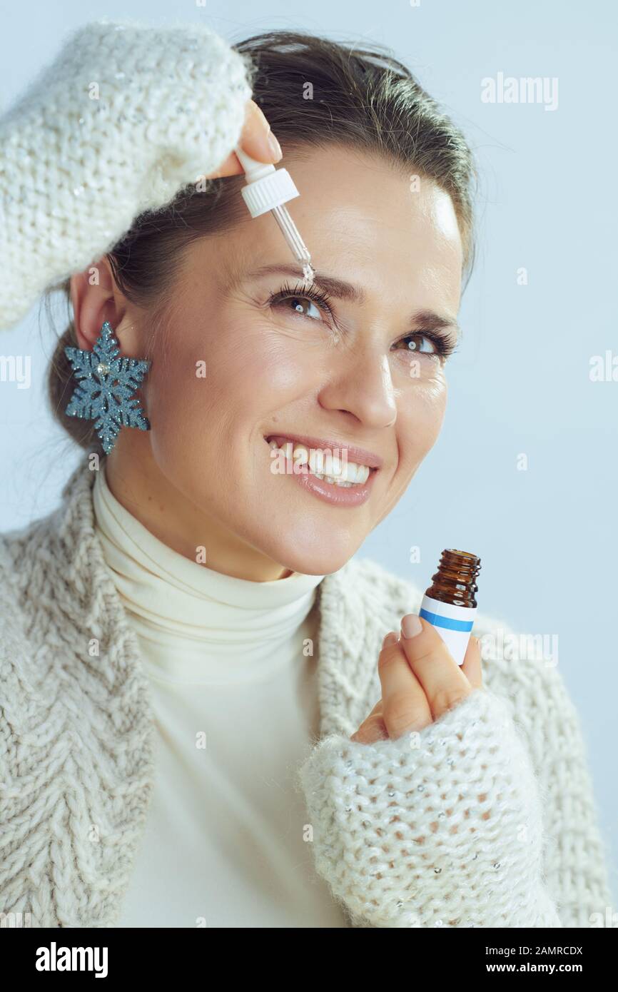 femme souriante et élégante de 40 ans dans un gilet et un pull à col roulé  avec contour d'oreille en flocons de neige et gouttes pour les yeux pour  les yeux d'hiver