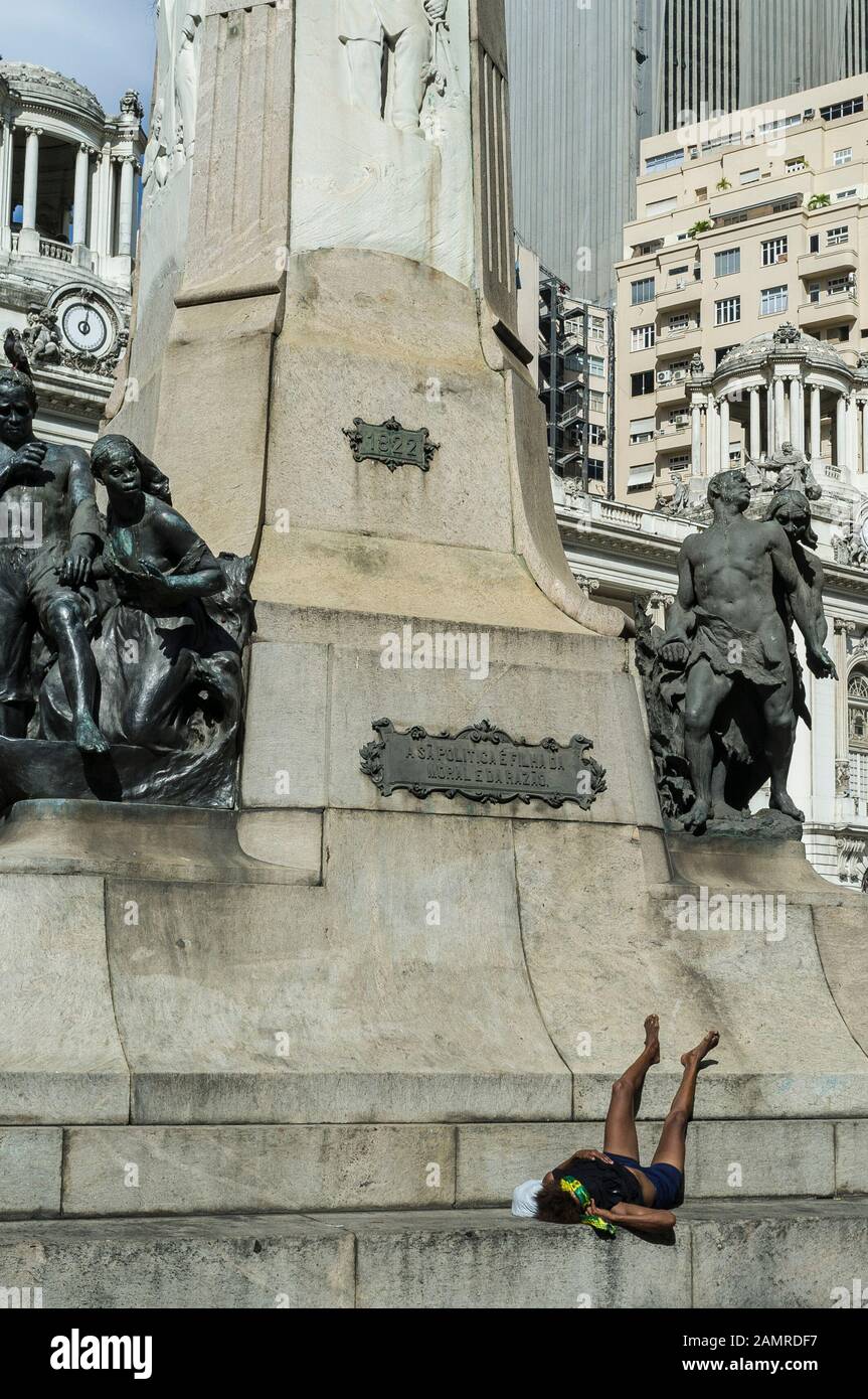 Une femme sans abri dort à la base du monument historique de la place Cinelandia dans le centre-ville de Rio de Janeiro. Banque D'Images