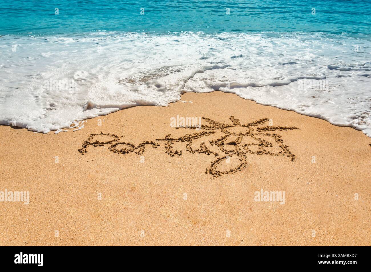 Texte écrit à la main Portugal et symbole du soleil sur la plage de sable doré avec des vagues à venir. Concept de vacances chaudes d'été et de vacances à la mer ou à l'océan Banque D'Images