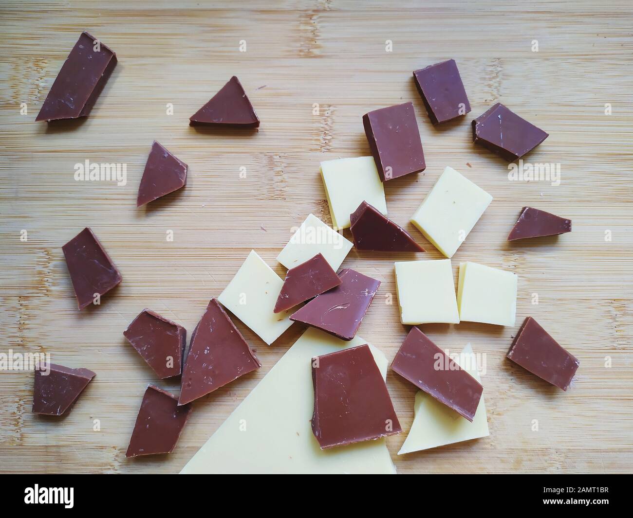 Chocolat blanc, chocolat au lait et éclats de chocolat noir sur une table en bois Banque D'Images