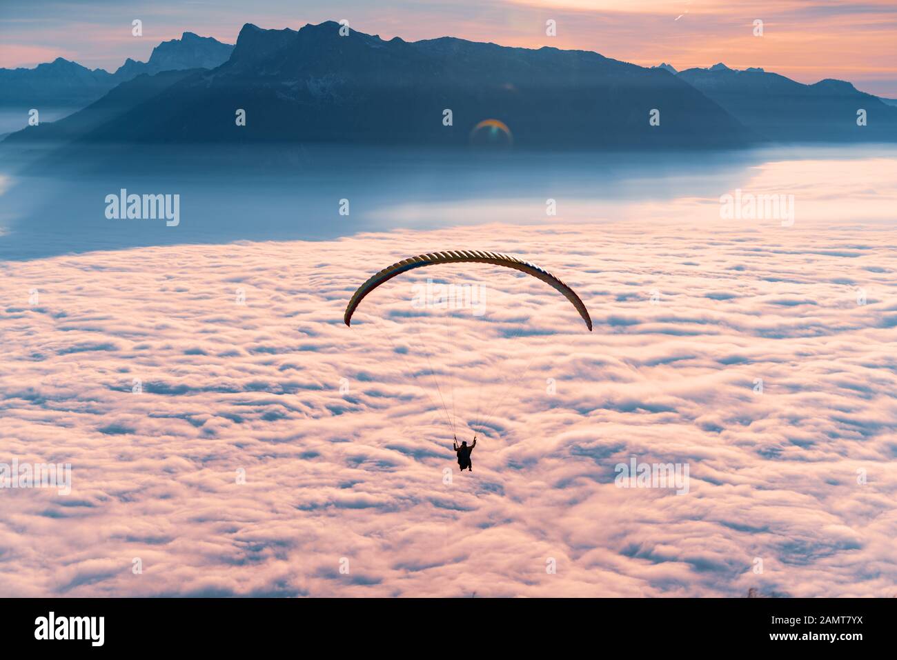 Silhouette D'un Parapente volant au-dessus du tapis de nuages au coucher du soleil, Gaisberg, Salzbourg, Autriche Banque D'Images