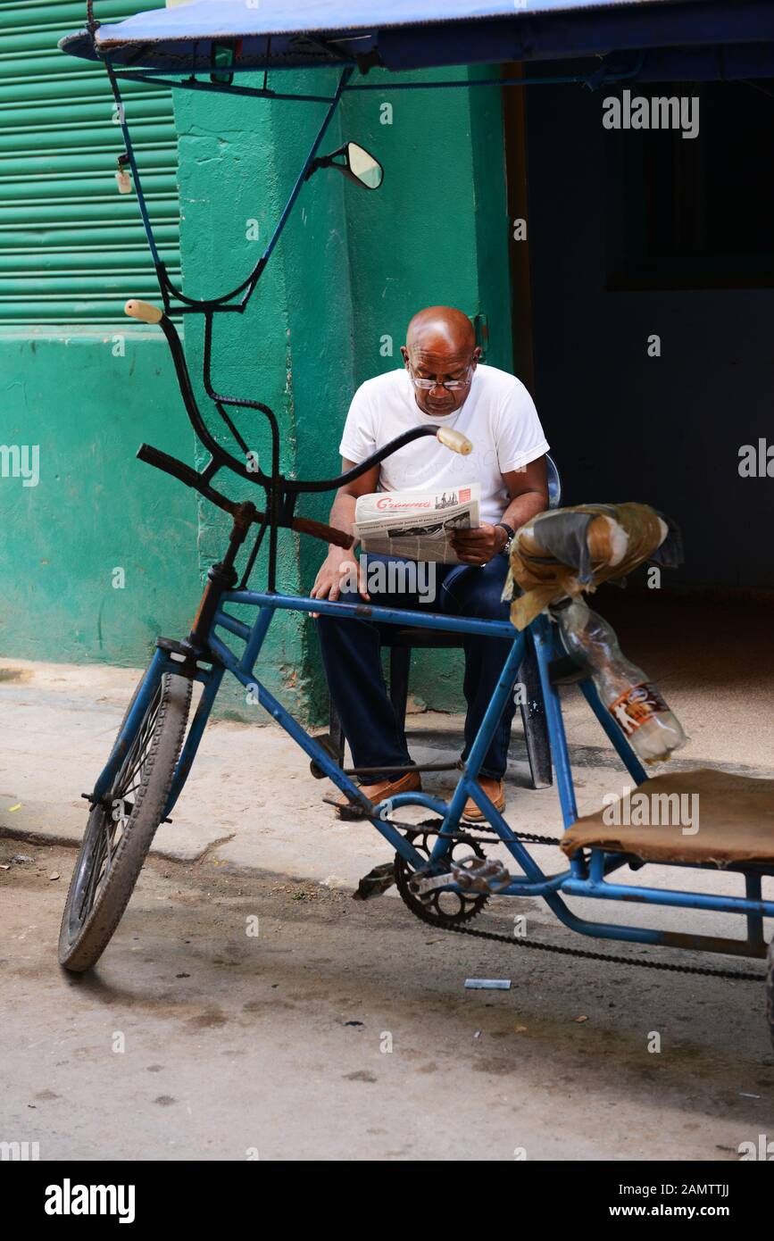 Un homme cubain lisant le journal de la vieille Havane, Cuba. Banque D'Images