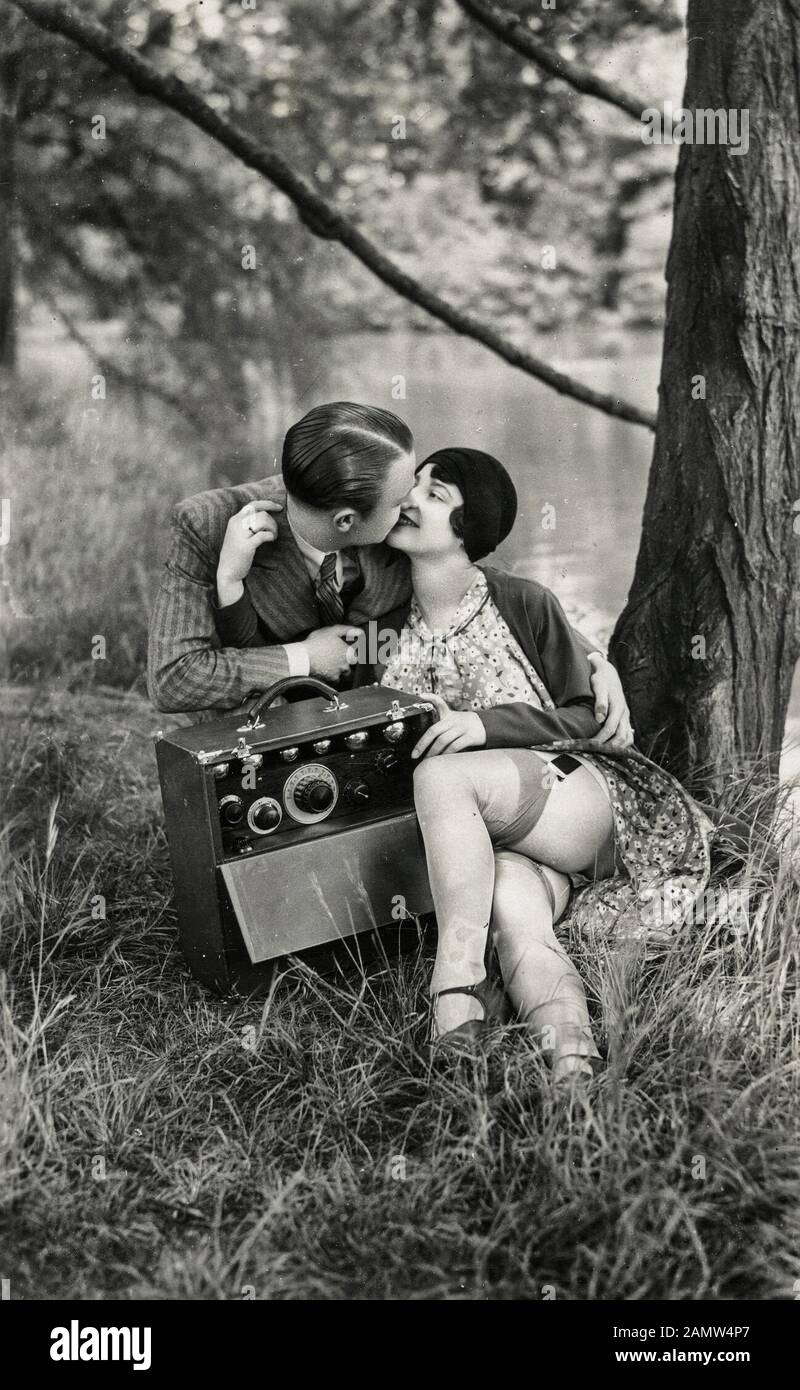 Scène de flapper dans les années 1920 - un homme et une femme embrassent dans les bois Banque D'Images