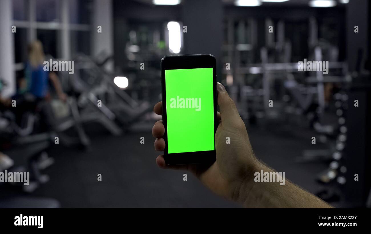 Sportif qui vérifie l'application en ligne du smartphone, le pouls de surveillance, l'écran vert Banque D'Images
