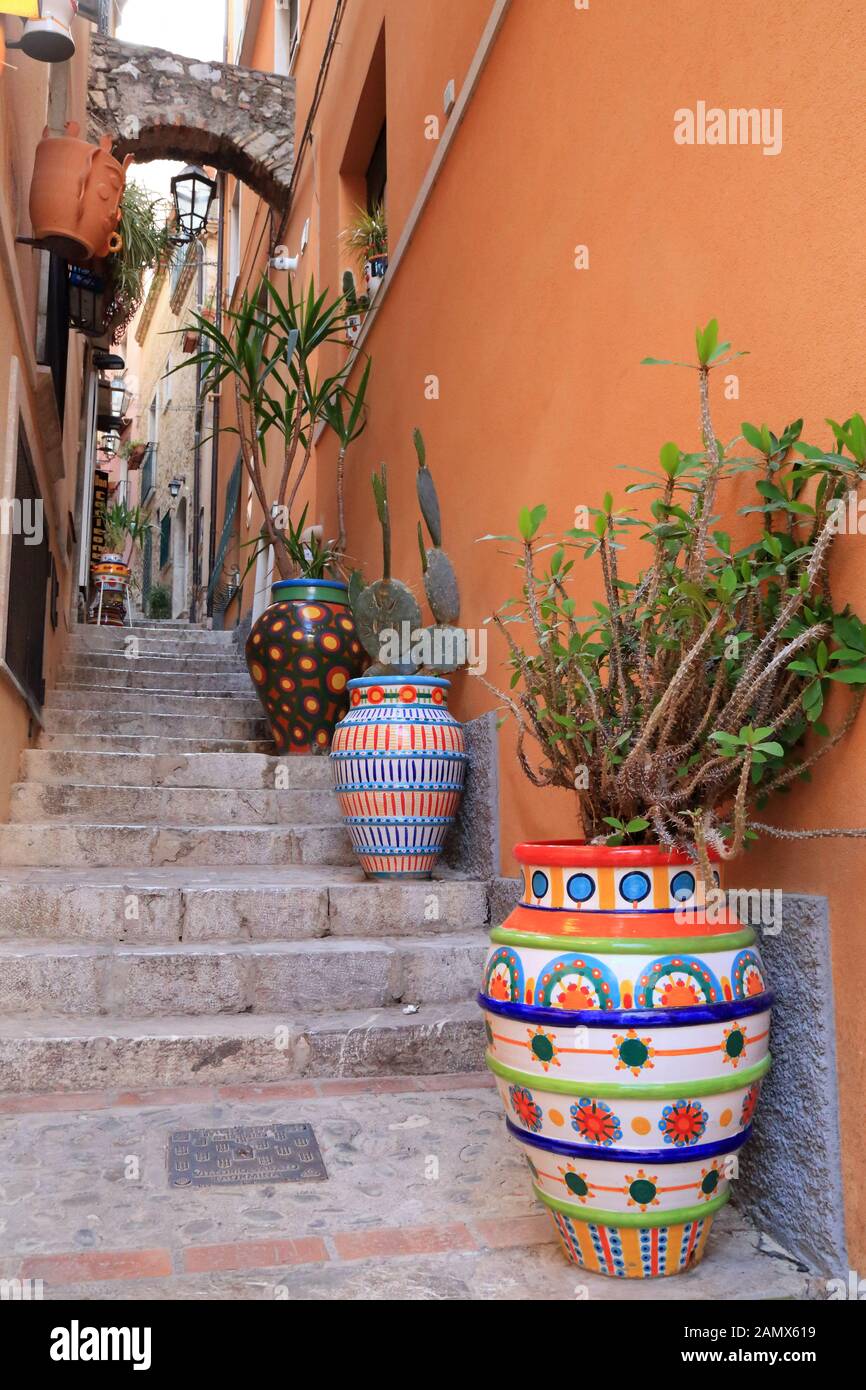 Rue étroite avec pots de fleurs colorés à Taormine Banque D'Images