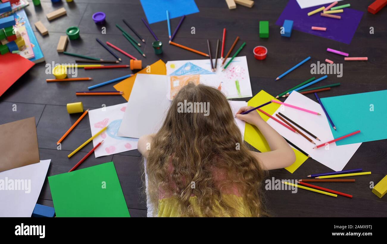 Jeune fille blonde préscolaire dessin avec des crayons colorés à l'heure du loisir, l'enfance Banque D'Images