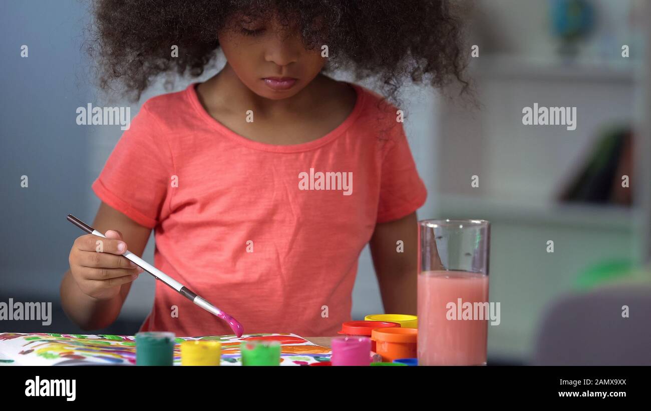 Jolie petite fille à poil noir avec peinture aux aquarelles à l'école d'art, l'éducation Banque D'Images