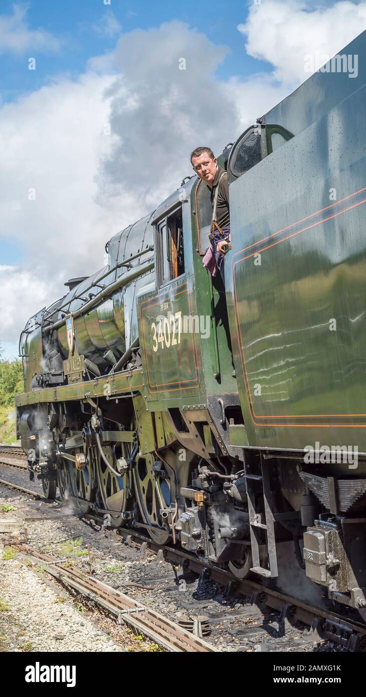 Vue latérale ancienne locomotive à vapeur britannique Taw Valley 34027 sur la ligne du patrimoine ferroviaire de Severn Valley en été soleil. Le membre d'équipage de la cabine Loco est à la recherche. Banque D'Images