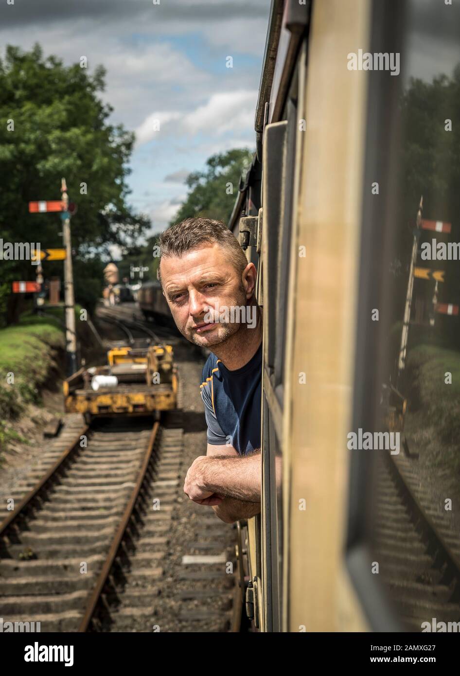 Homme regardant par une voiture de chemin de fer d'époque à bord du train à vapeur britannique, Severn Valley Heritage Steam Railway. Banque D'Images