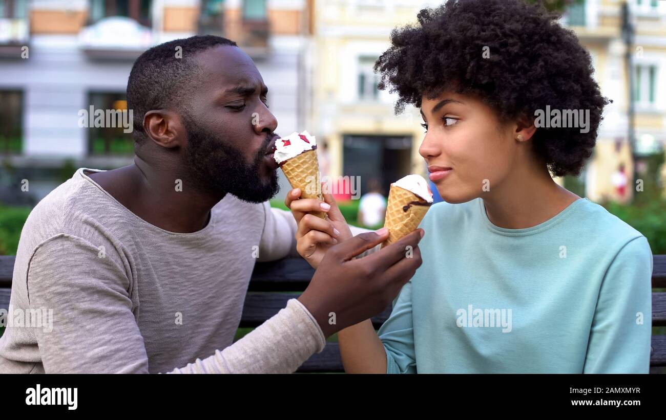 Aimez les partenaires qui partagent la glace pendant la date d'été dans le parc de la ville, s'amuser ensemble Banque D'Images