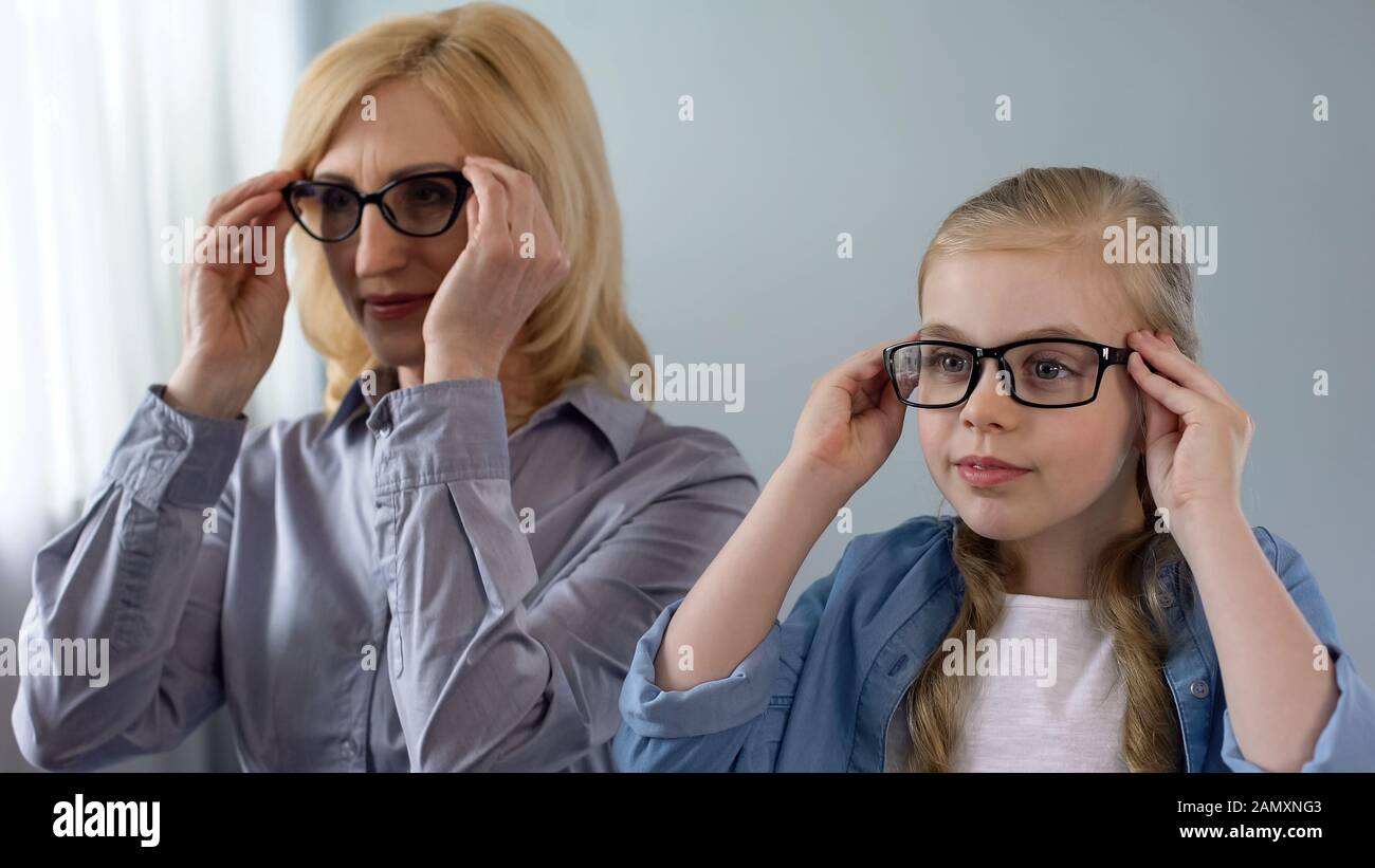 Petite fille blonde mettant des lunettes, veut ressembler à grand-mère, famille Banque D'Images