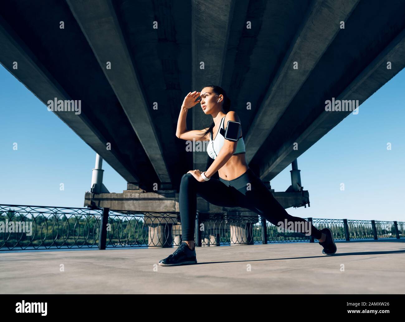 Sporty woman runner stretching jambes pour se réchauffer avant d'exercer et à la voiture. L'entraînement en milieu urbain et l'exécution de concept Banque D'Images