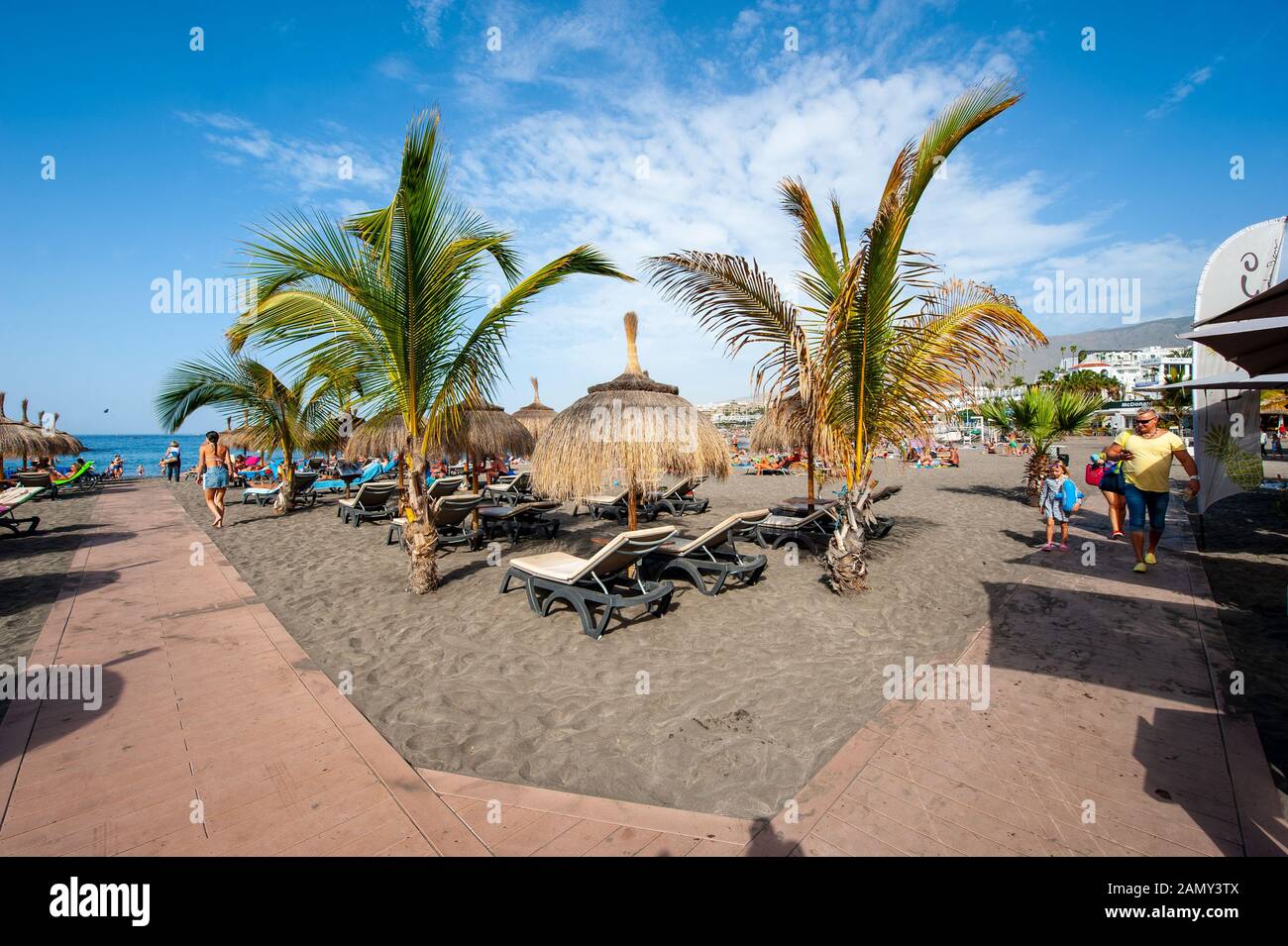 Île des Canaries TENERIFE, ESPAGNE - 26 DEC, 2019: Les touristes ment et se détendent entre palmiers et chaises longues sur la plage appelée playa de torviscas. Banque D'Images