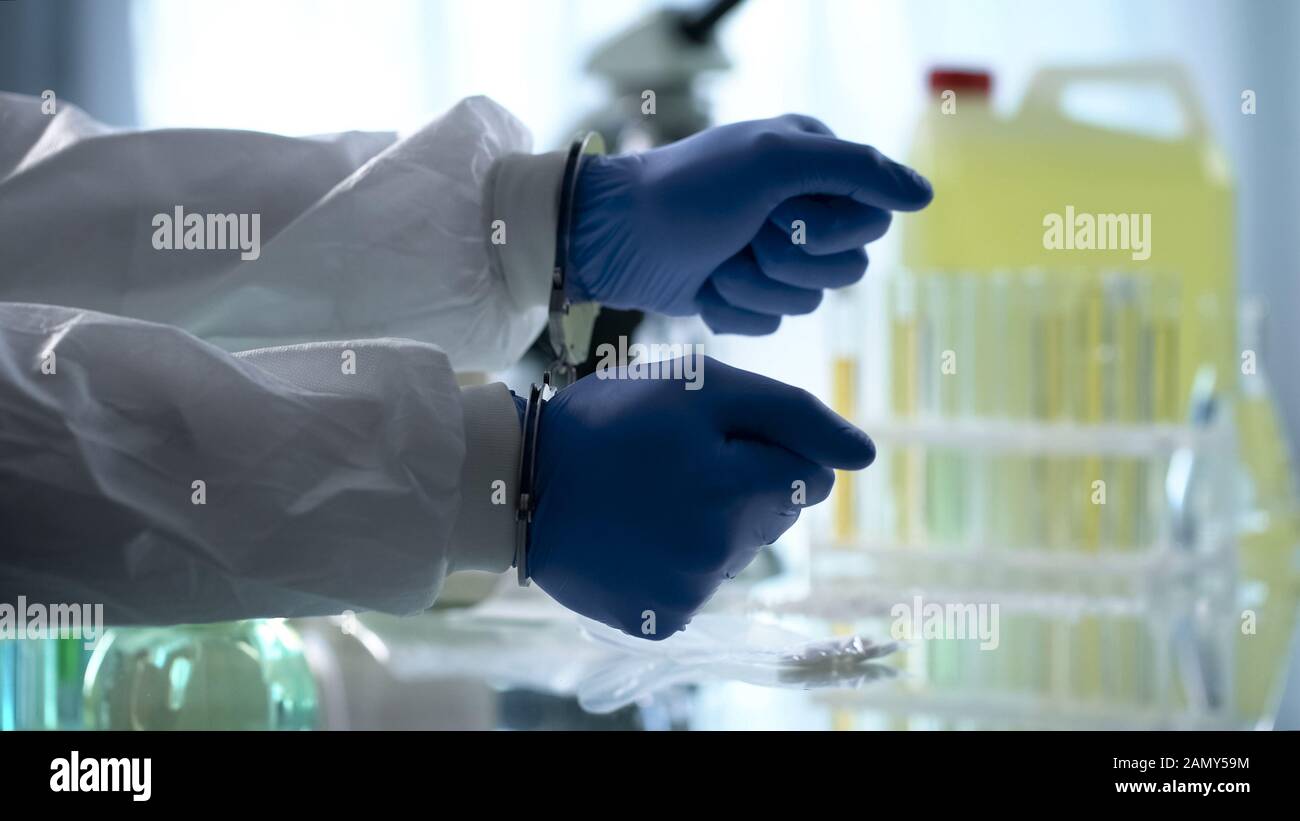 Assistant de laboratoire menotté pour les drogues illégales traitant le laboratoire pharmaceutique clandestin Banque D'Images