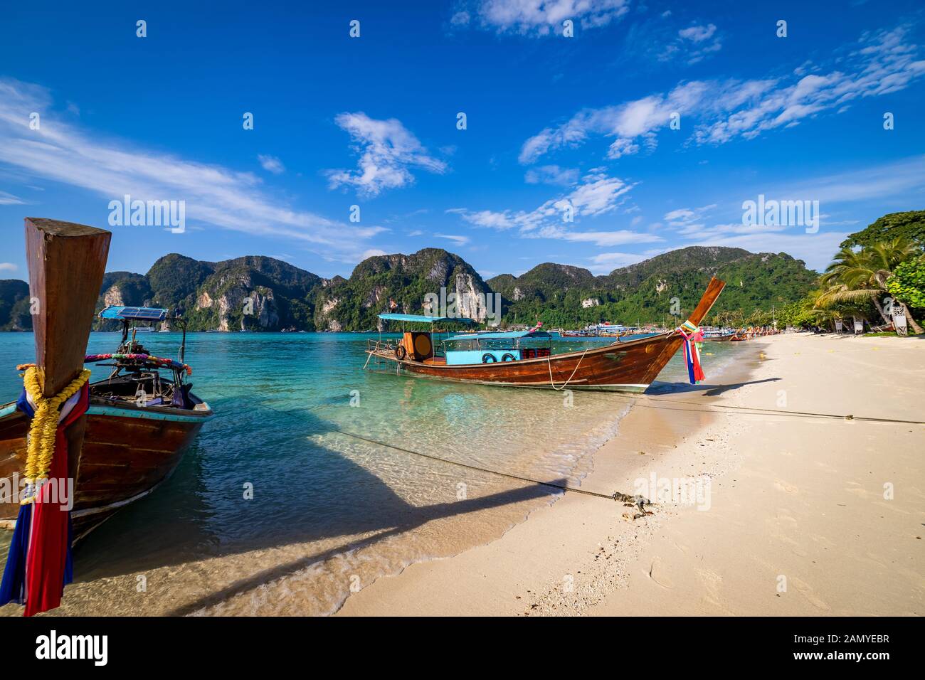 Bateaux longtail traditionnels en bois stationnée à une plage à Phi Phi Island. L'eau claire et propre plage. Banque D'Images