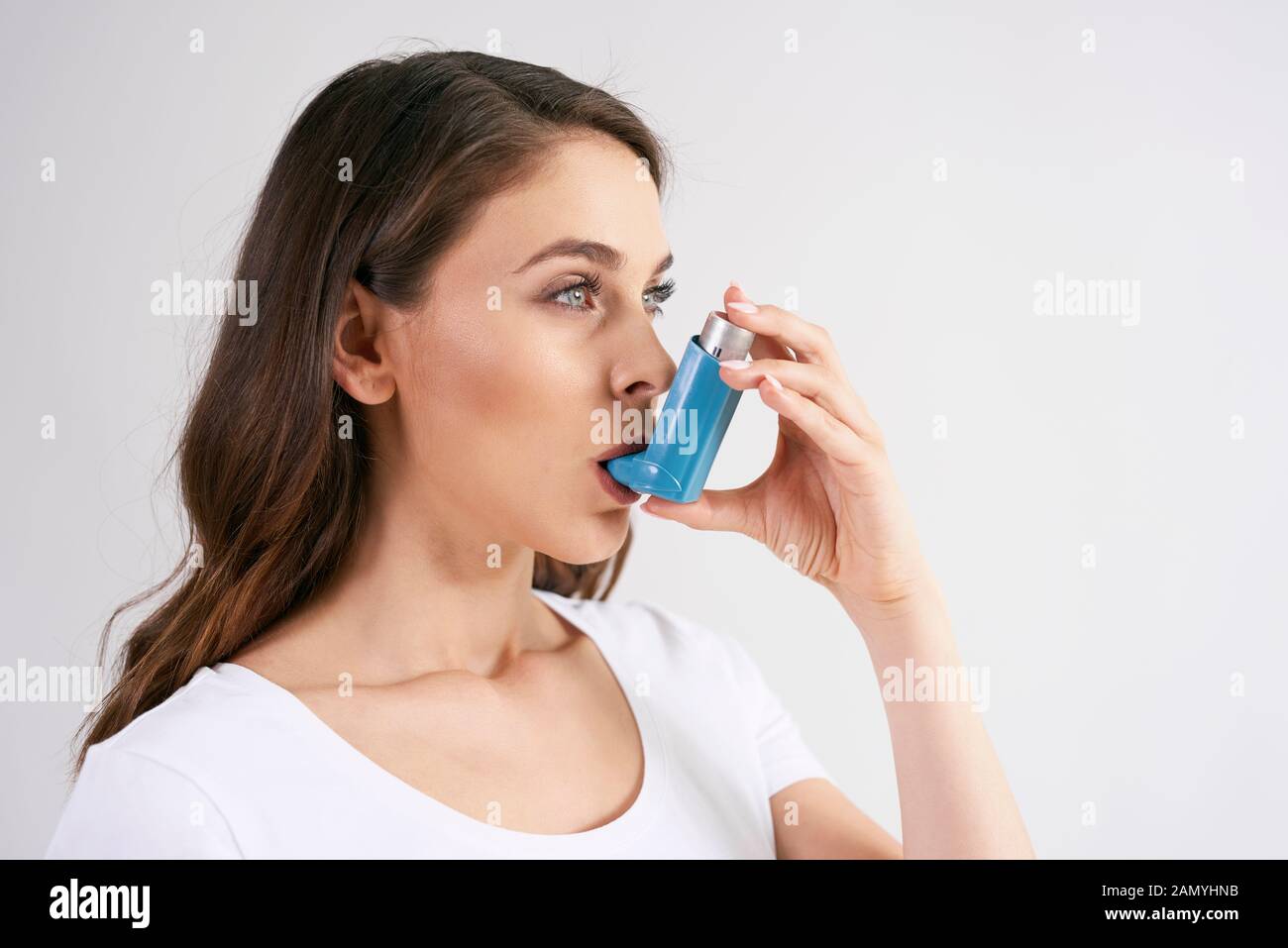 Femme asthmatique utilisant un inhalateur d'asthme pendant les crises d'asthme Banque D'Images