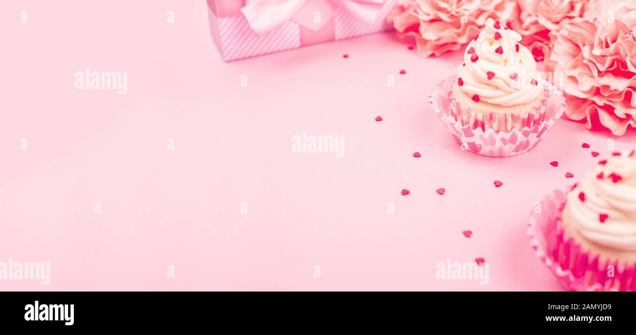 Amour saint valentin décoration cupcake à la crème et rose fleurs et coeurs sur fond rose cadeaux avec copie espace pour le texte Banque D'Images