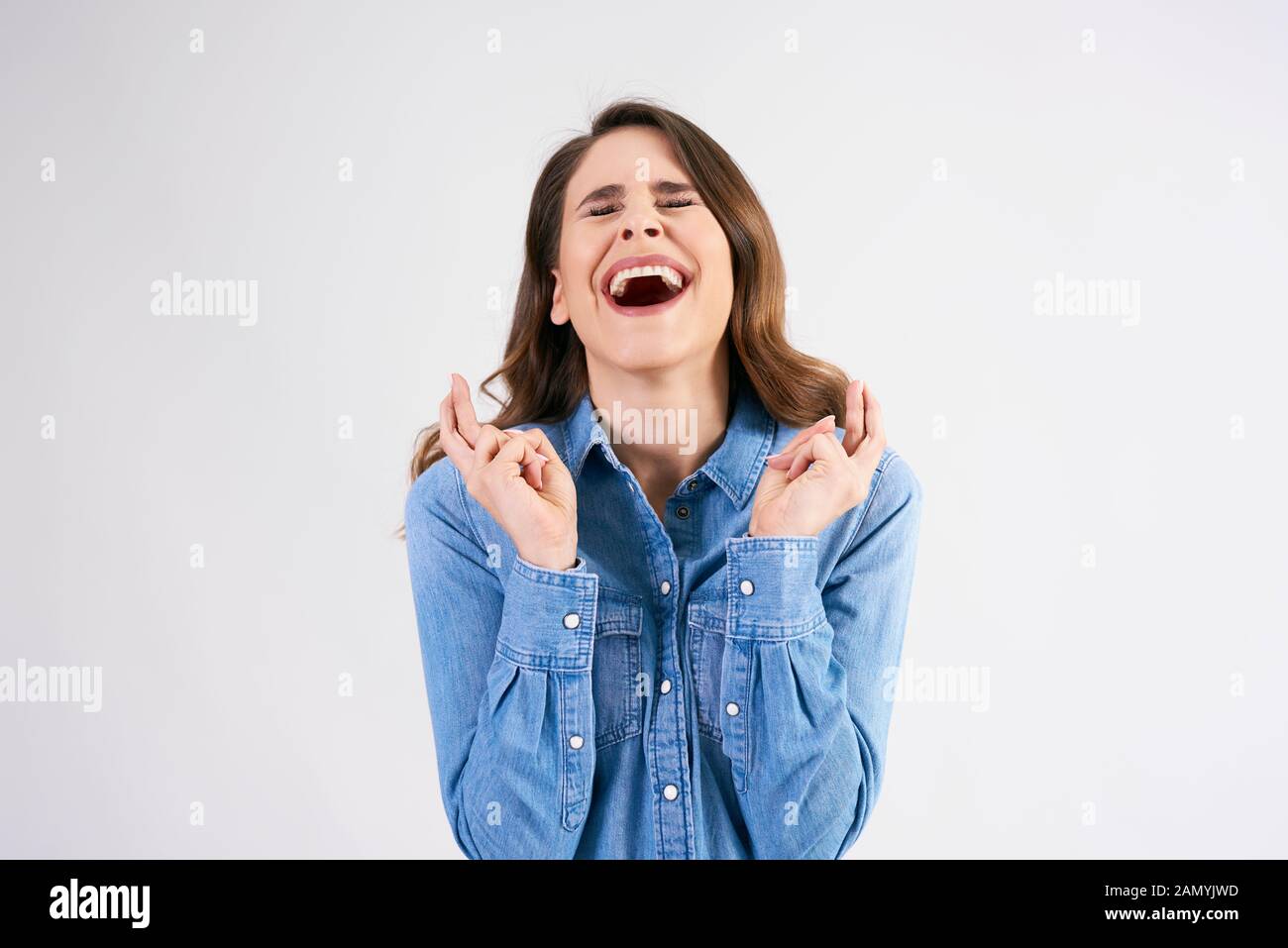 Jeune femme croisant les doigts et souhaitant bonne chance Banque D'Images