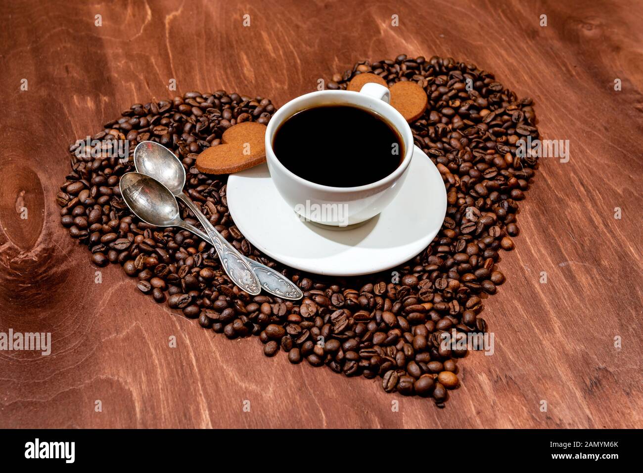 Tasse à café blanc, d'épices en forme de coeur et deux cuillères sur une base en forme de coeur fait avec des grains de café - image Banque D'Images