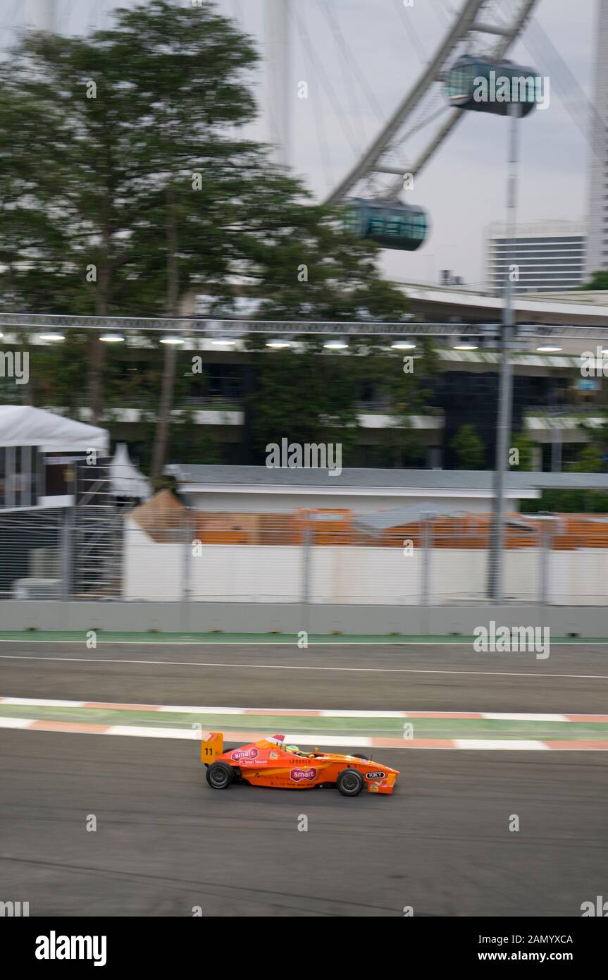 Les voitures de course de Formule 2 avec le Singapore Flyer en arrière-plan, Grand Prix de Singapour, Central Business District, Singapour Banque D'Images