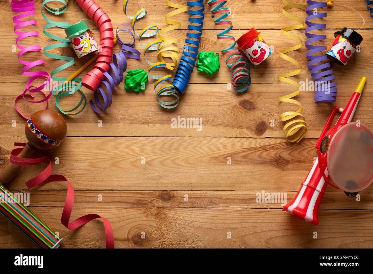 Arrière-plan de carnaval sur une surface en bois. Masques, chapeaux, serpentins, confettis serpentins Banque D'Images
