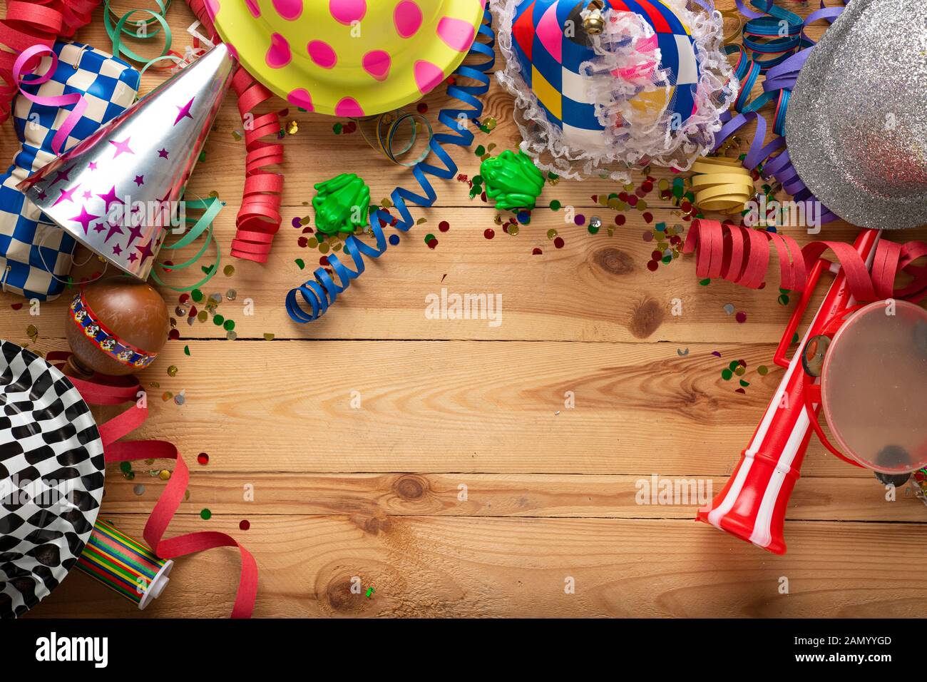 Arrière-plan de carnaval sur une surface en bois. Masques, chapeaux, serpentins, confettis serpentins Banque D'Images