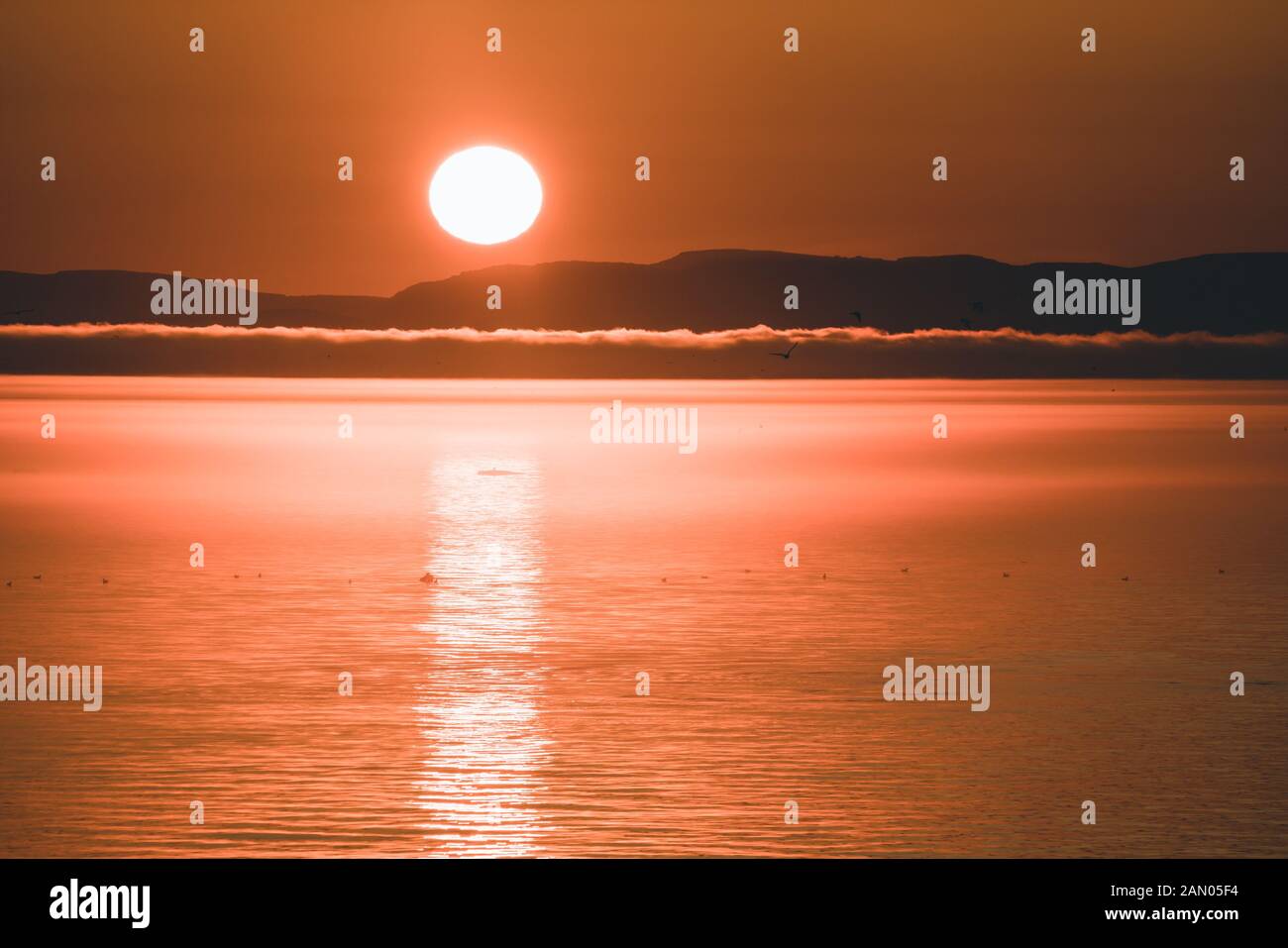 Beau coucher de soleil avec montagnes et icebergs. Cercle arctique et océan. Horizon du lever du soleil avec ciel rose pendant le soleil de minuit. Banque D'Images