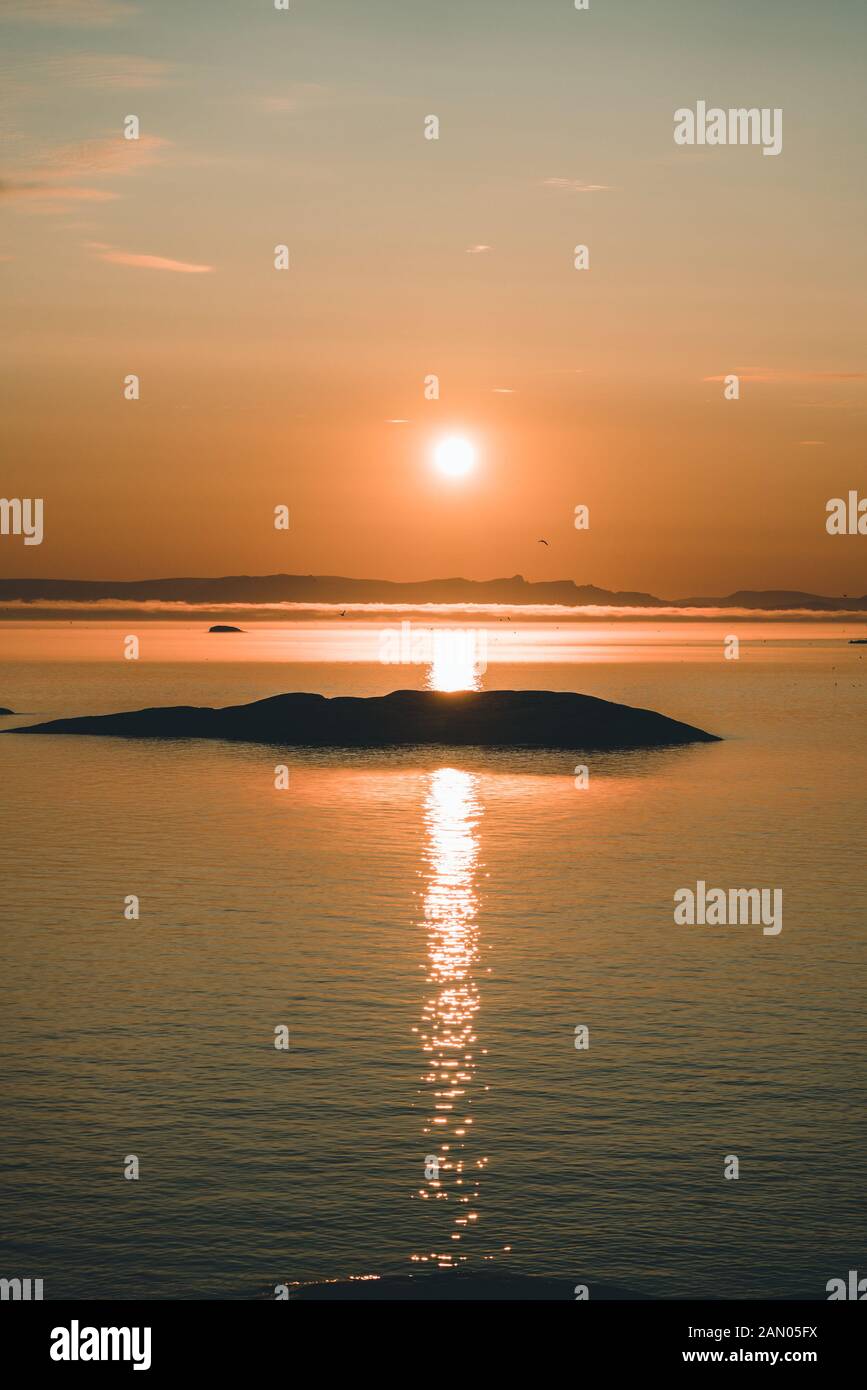 Beau coucher de soleil avec montagnes et icebergs. Cercle arctique et océan. Horizon du lever du soleil avec ciel rose pendant le soleil de minuit. Banque D'Images