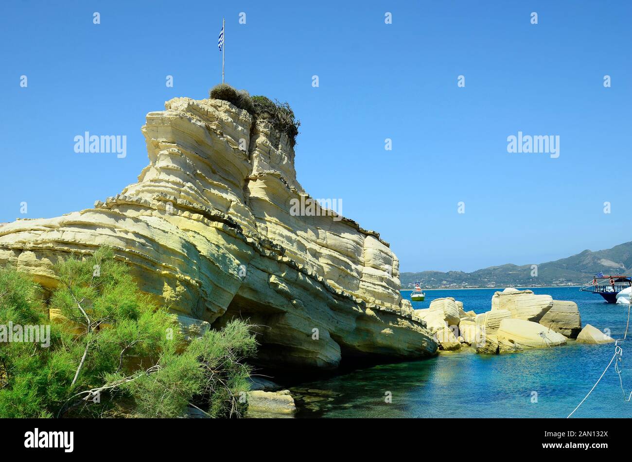 La Grèce, l'île de Zakynthos, rock avec drapeau grec à Agios Sostis Banque D'Images