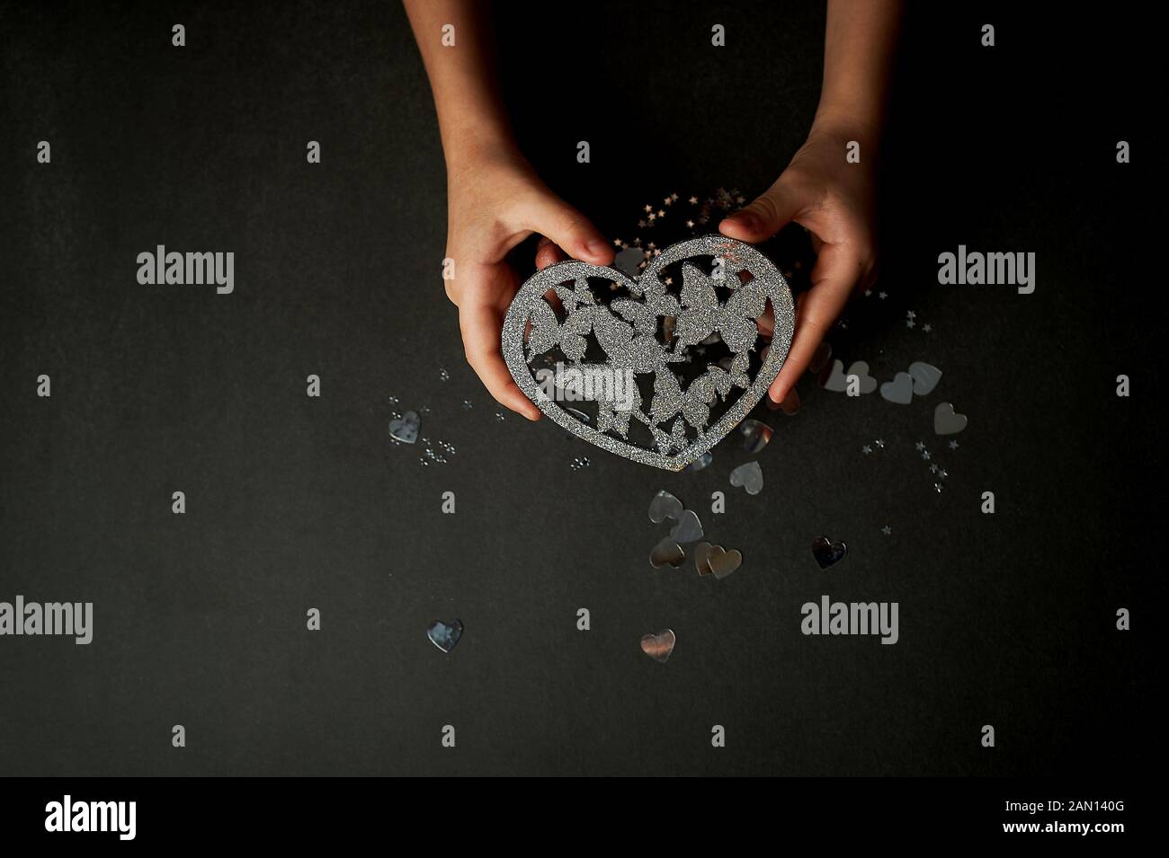 Saint Valentin Une Declaration D Amour Coeur Argente Avec Papillons Papillons Dans L Estomac Dans Les Mains Photo Stock Alamy