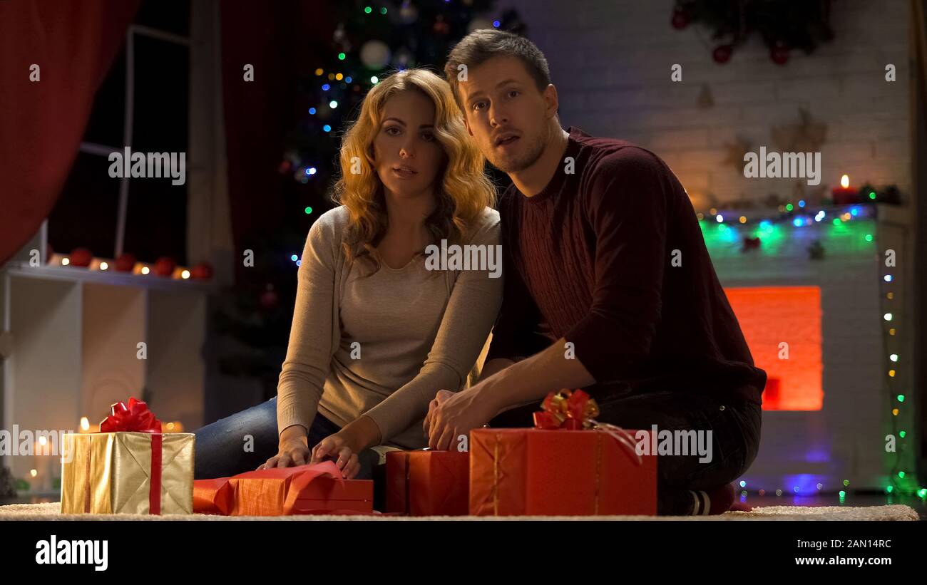 Les parents pris pendant l'emballage des cadeaux de Noël sous l'arbre de Noël, déception Banque D'Images