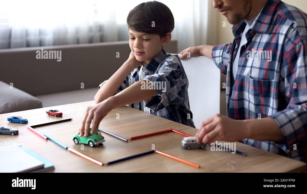 Père gentil jouant des voitures de jouet avec son petit fils, le soin parental, la togethité Banque D'Images