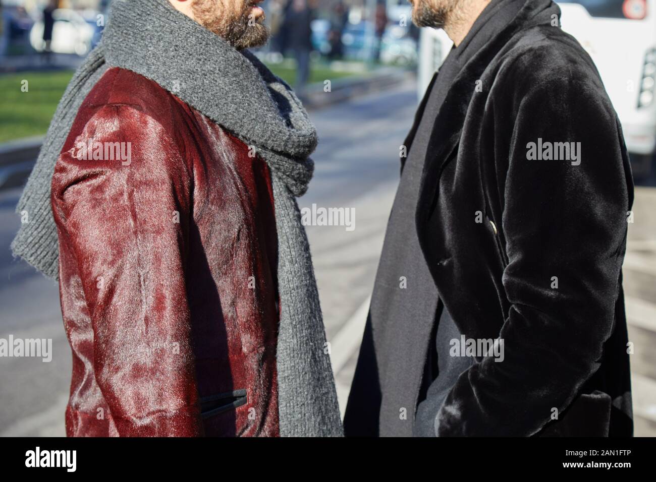 Milan, ITALIE - 11 JANVIER 2019 : hommes avec manteau en cuir de fourrure  rouge et veste en velours noir avant le défilé de mode Emporio Armani, rue  de la semaine de