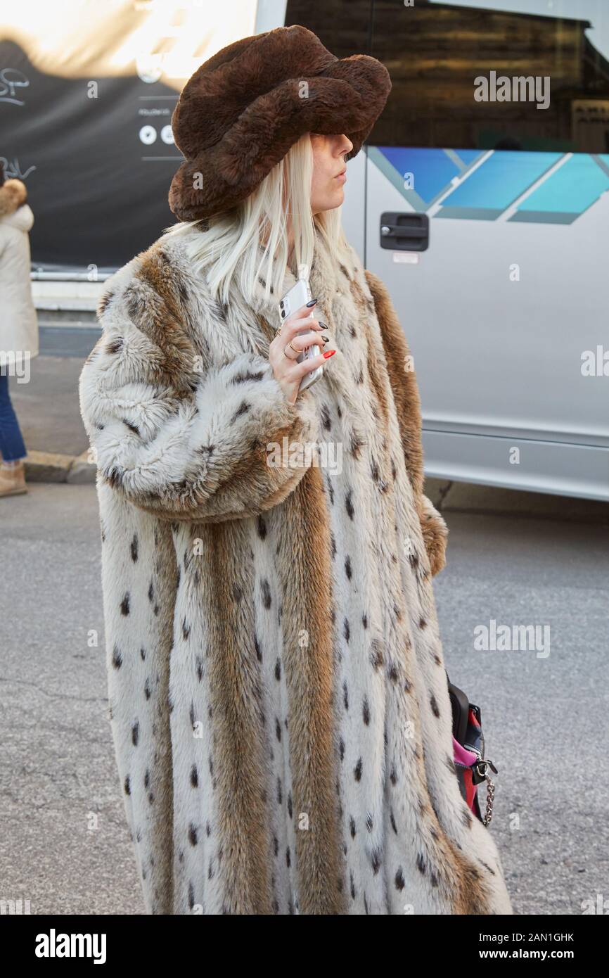 Milan, ITALIE - 11 JANVIER 2019 : femme avec un long manteau de fourrure et chapeau avant le défilé de mode Marni, style de rue de la semaine de la mode de Milan Banque D'Images