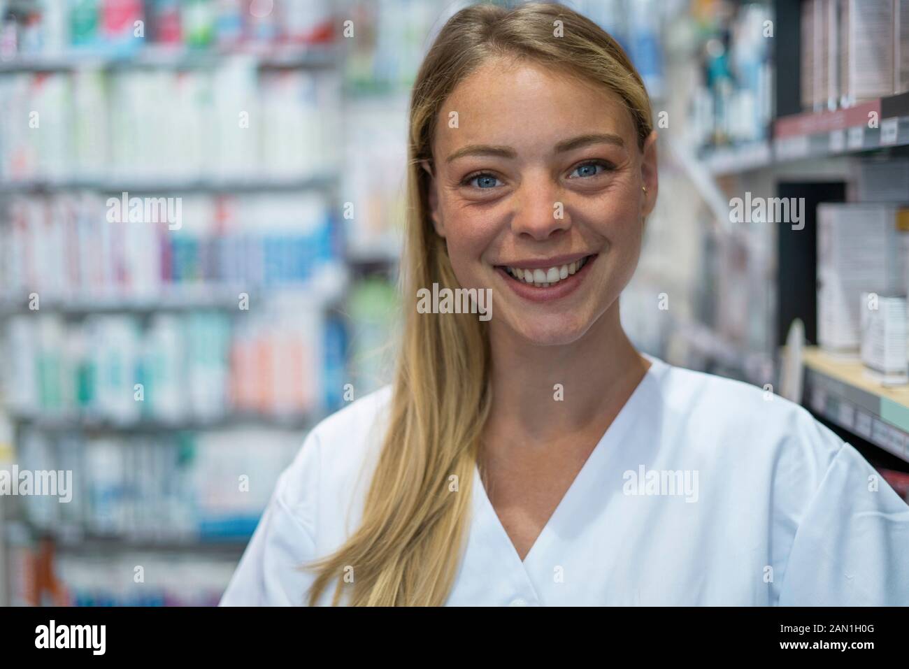 Portrait de la jeune femme souriante debout en pharmacie Banque D'Images