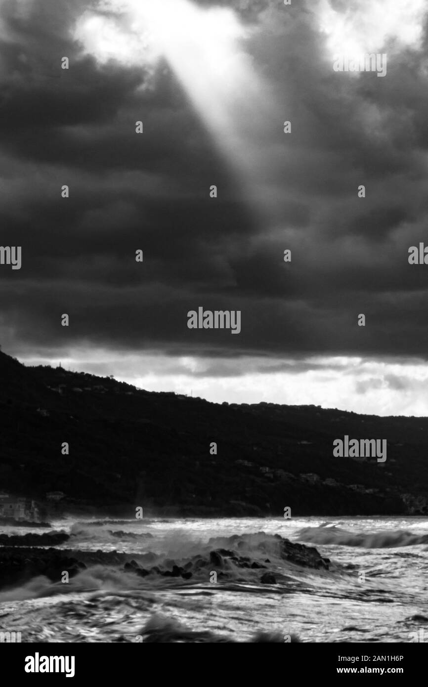 Côte de Calabre, Italie : afficher en noir et blanc de la Marina plage de Pizzo Calabro sur un jour d'hiver orageux, de la jetée et de la plage avec des vagues Banque D'Images