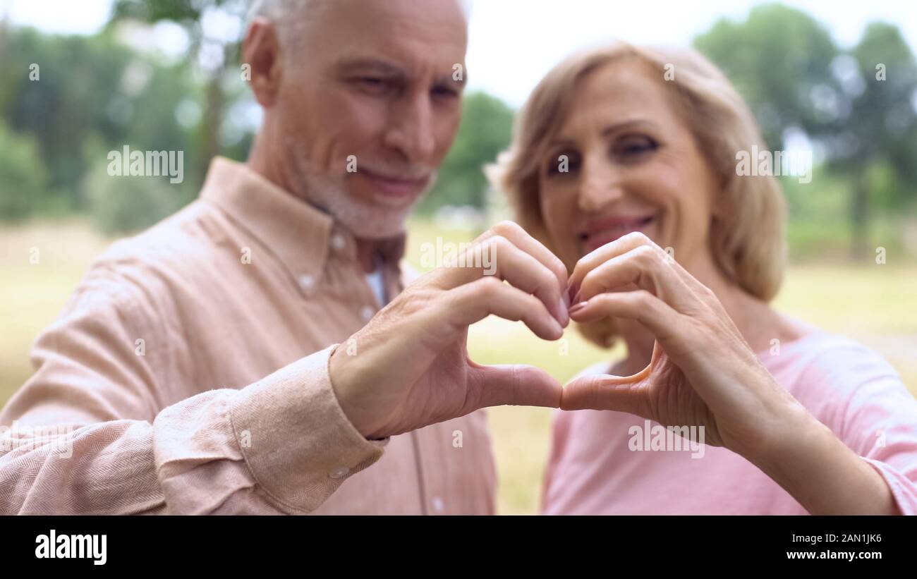 Happy senior couple montrant coeur geste, solidarité, amour romance soul mates Banque D'Images