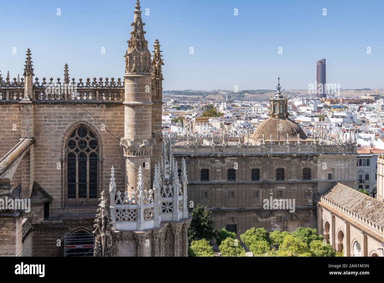 La hausse sur le Patio de los Naranjos, La Cathédrale de Séville et la coupole de l'Église Sagrario contraste avec la Torre Séville moderne dans la distance Banque D'Images