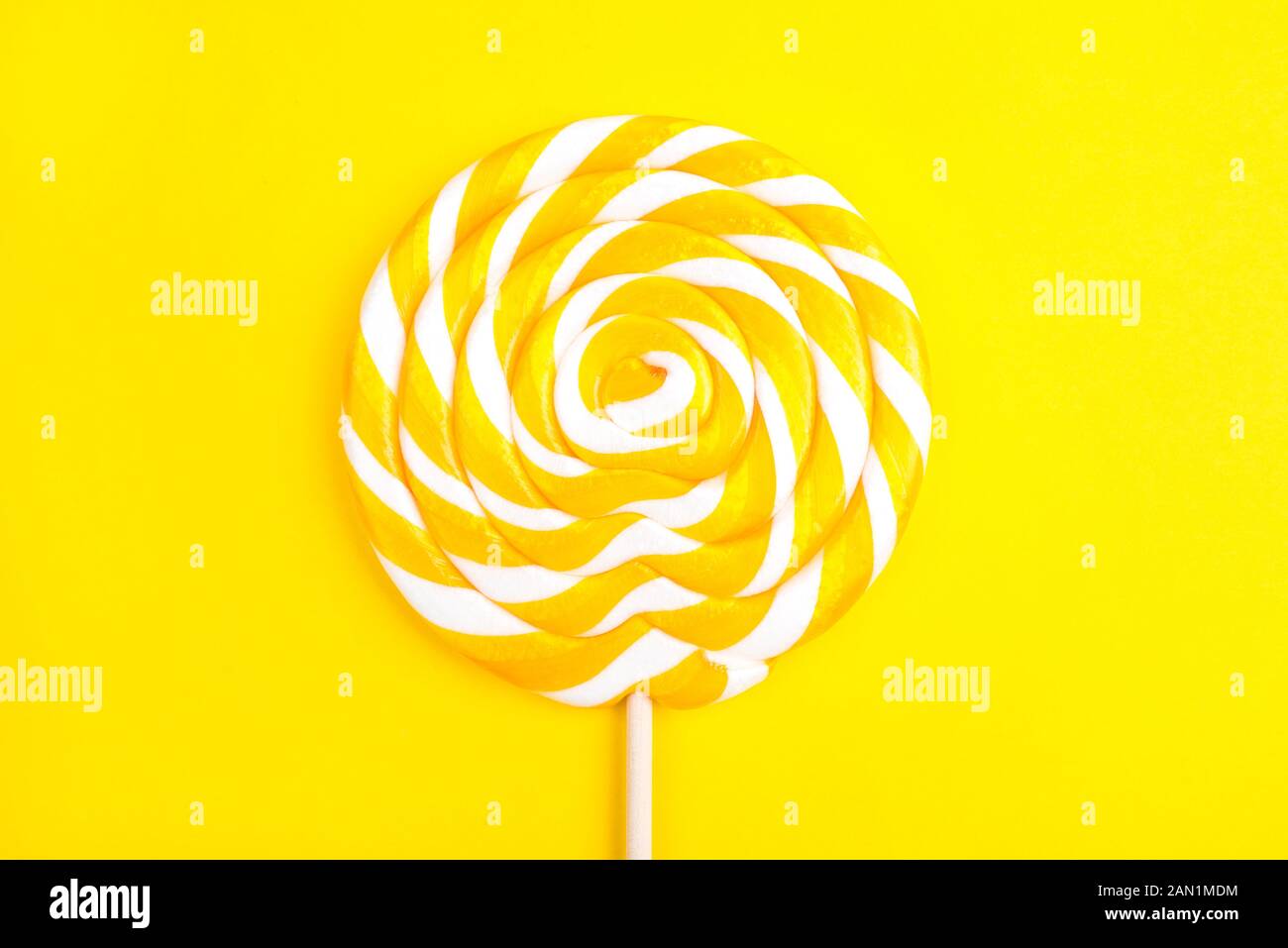 Sucette jaune en forme d'un cercle sur un fond jaune. Banque D'Images