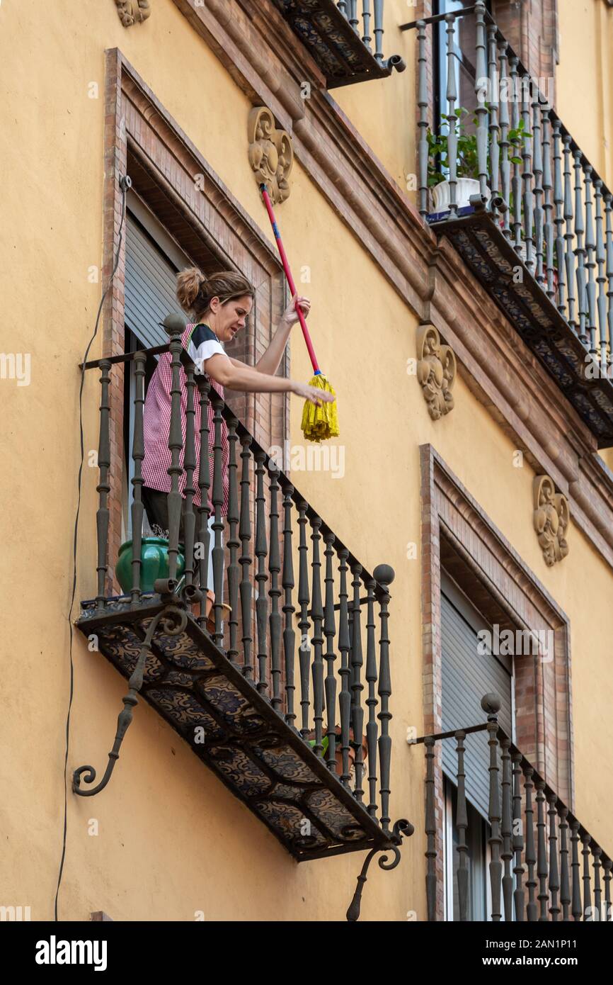 Un nettoyant secouant une serpillière sur un balcon d'un immeuble  d'appartements à Séville Photo Stock - Alamy