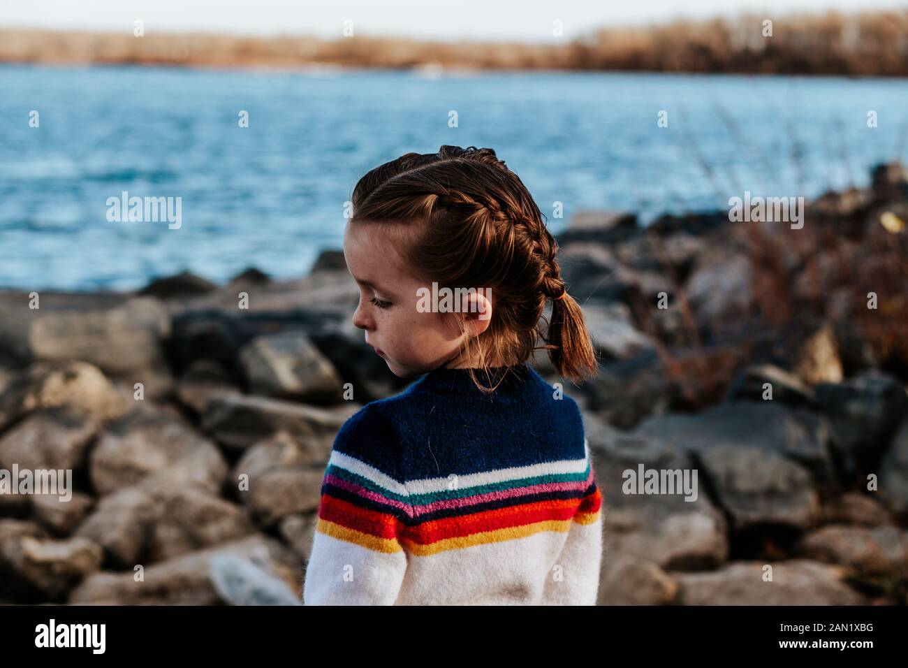 portrait d'une jeune fille qui regarde loin sur des rochers au lac Banque D'Images