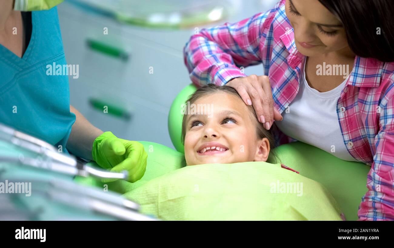 Smiling preschool girl visiter dentiste, aucune crainte après la procédure, la dentisterie pour les enfants Banque D'Images