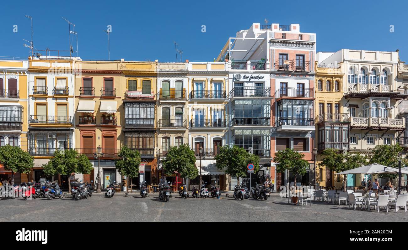 Des bâtiments colorés (et des motos garées) s'alignent sur le côté est de la Plaza de San Francisco à Séville. Banque D'Images