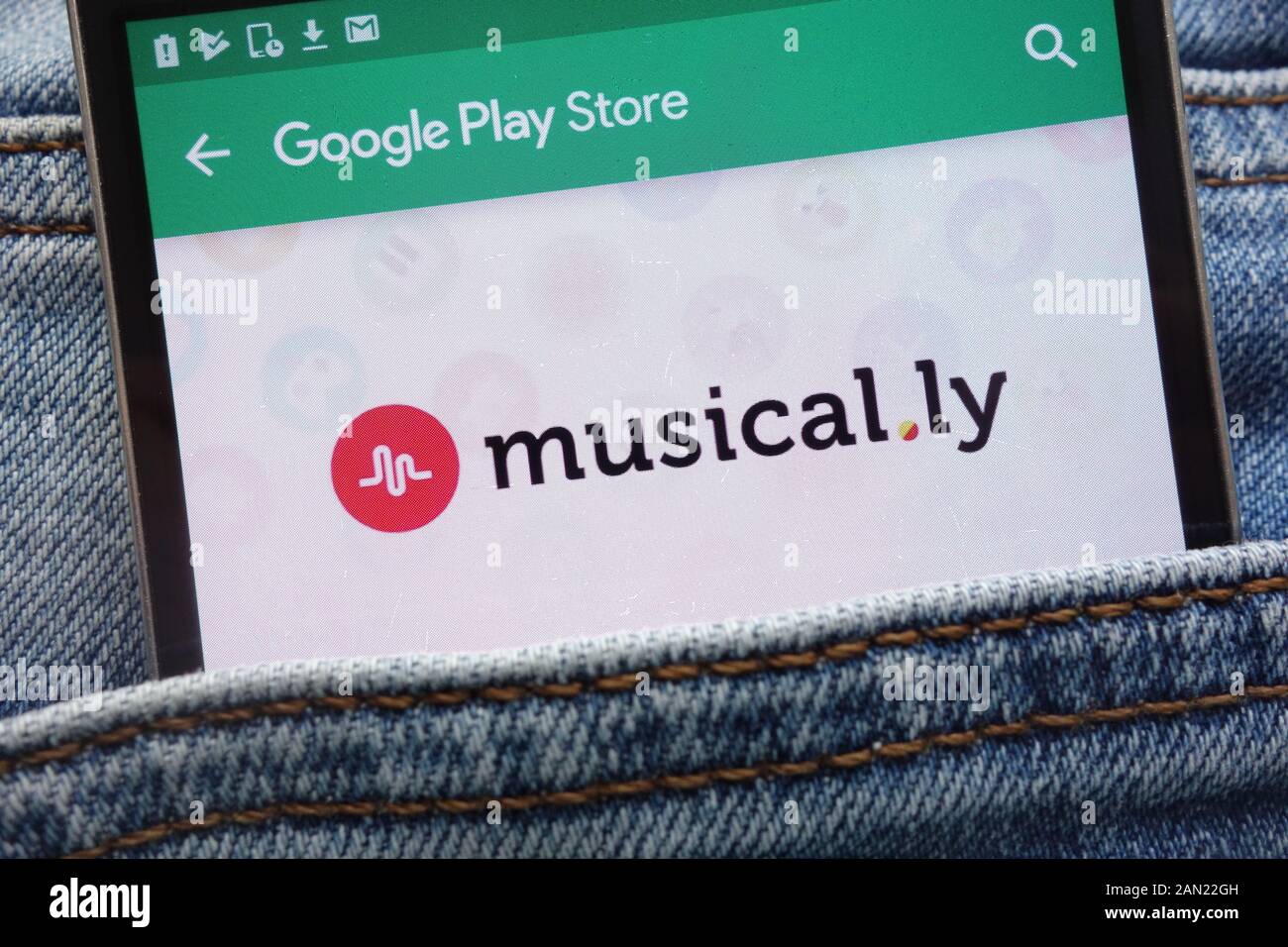 Encore de.ly app sur Google Play Store affiche site web sur smartphone caché dans la poche de jeans Banque D'Images