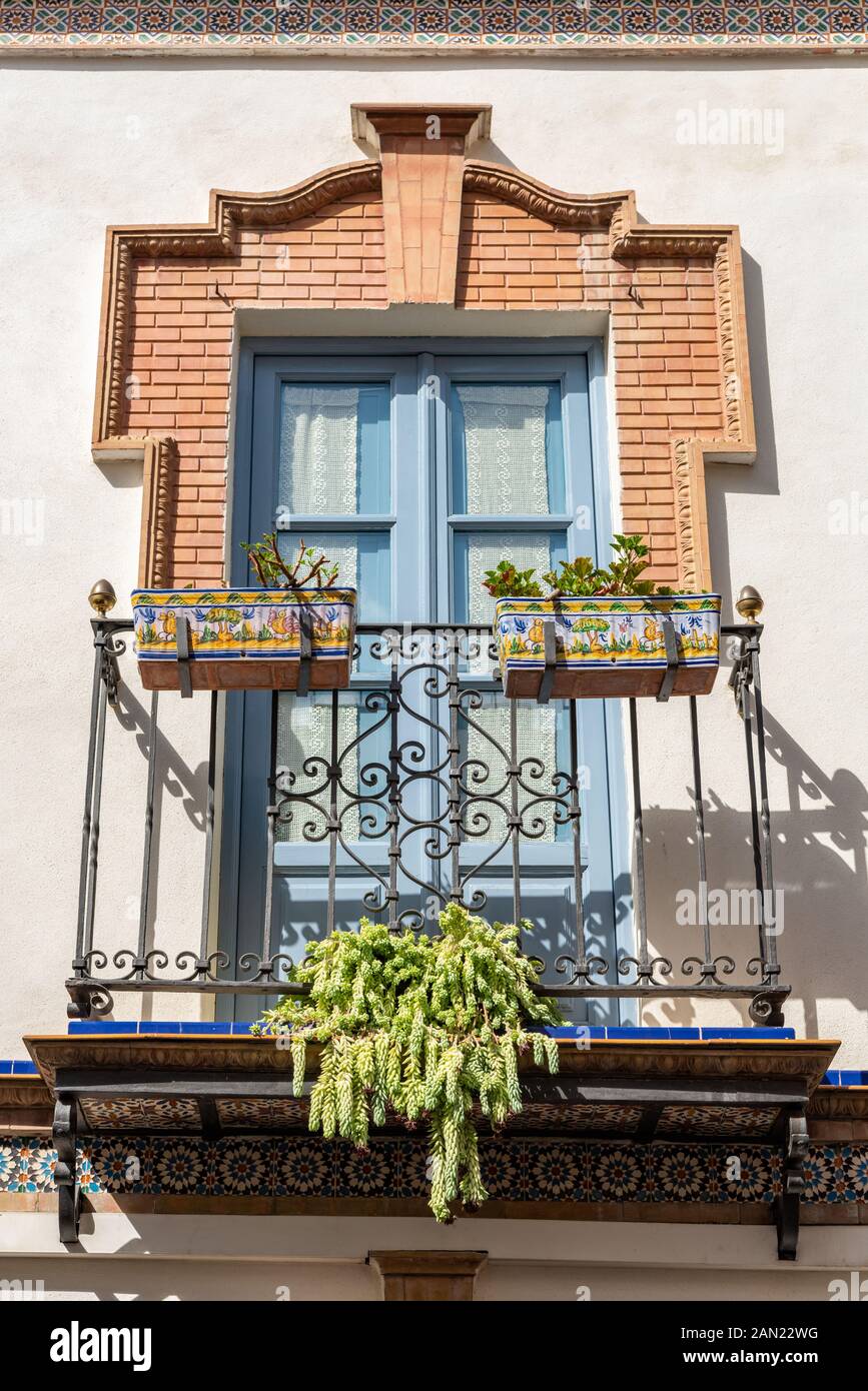 Un cadre en briques élaborées orne les fenêtres françaises sur un balcon dans une maison de la Calle Pelay Correa à Triana, Séville Banque D'Images