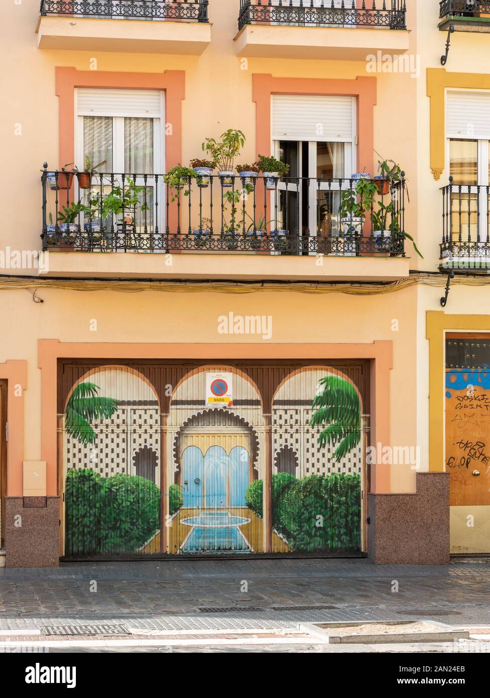 Une maison colorée sur la Plaza San Juan de la Palma avec son balcon en fer forgé bordé de plantes en pot et sa cour ornée murale de jardin en contrebas. Banque D'Images