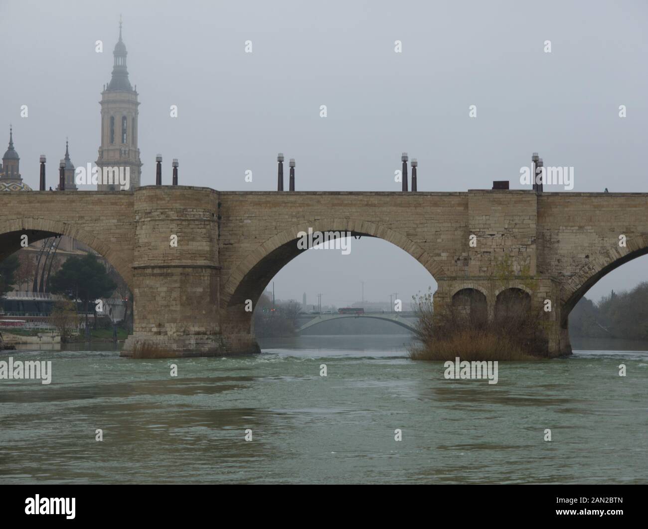 Pont de pierre et la Basilique de Notre-Dame du Pilier, vu de l'Èbre en un jour brumeux en hiver. Saragosse, Espagne. Banque D'Images