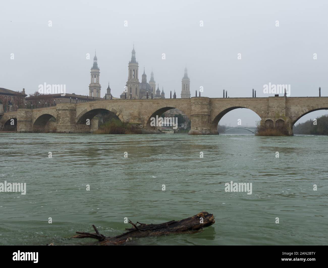 Pont de pierre et la Basilique de Notre-Dame du Pilier, vu de l'Èbre en un jour brumeux en hiver. Saragosse, Espagne. Banque D'Images